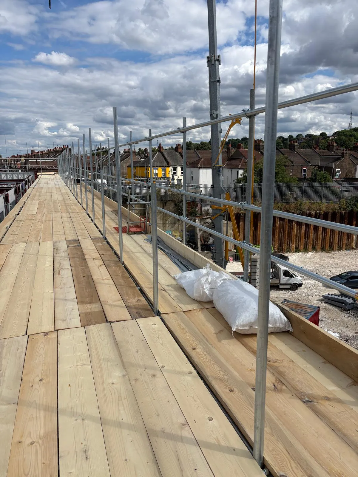 Fully boarded scaffolding working platform installed for a new build residential development in Luton by Aron Scaffolding Services.